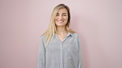Obraz premium Young blonde woman smiling confident standing over isolated pink background