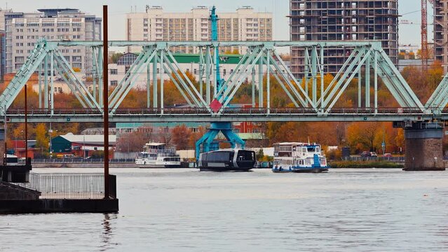 ships sails under the bridge at the Moskva river.  Tourist ferry ride on Moscow river. Autumn city landscape