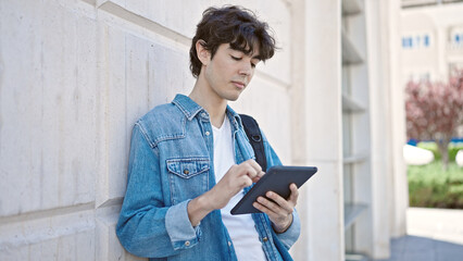 Young hispanic man student using touchpad at university