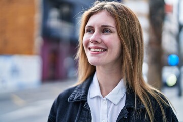 Young blonde woman smiling confident looking to the side at street