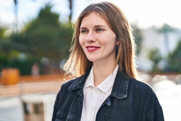 Young blonde woman smiling confident looking to the side at park