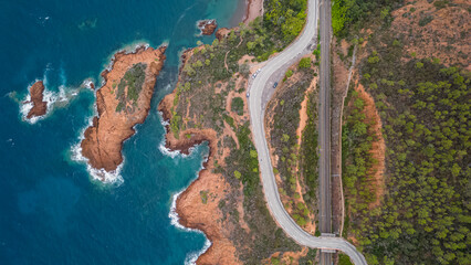 Aerial view of the Massif de L'Esterel and a beautiful winding road over the cliffs falling into...