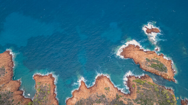 Aerial view of the Massif de L'Esterel and a beautiful winding road over the cliffs falling into the Mediterranean Sea. French Riviera. Cote d'Azur