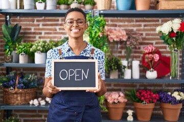 African american woman working at florist holding open sign smiling with a happy and cool smile on face. showing teeth.