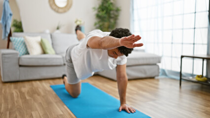 Young latin man training core exercise at home