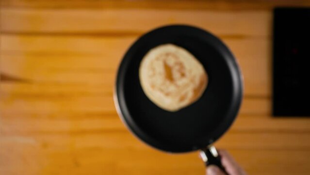 Cooking pancakes in a hot pan. Flipping pancake in up.