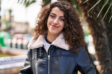 Young hispanic woman smiling confident standing at street