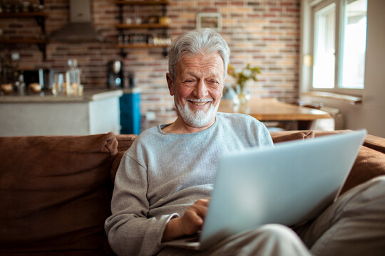 Senior Caucasian man using the laptop on the couch at home