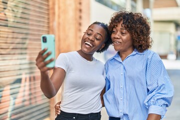 African american women mother and daughter having video call at street