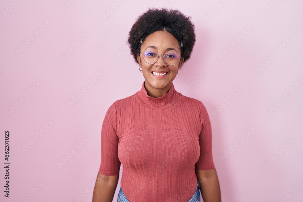 Sticker Beautiful african woman with curly hair standing over pink background with a happy and cool smile on face. lucky person.