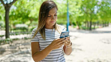 Middle eastern woman using smartphone at park