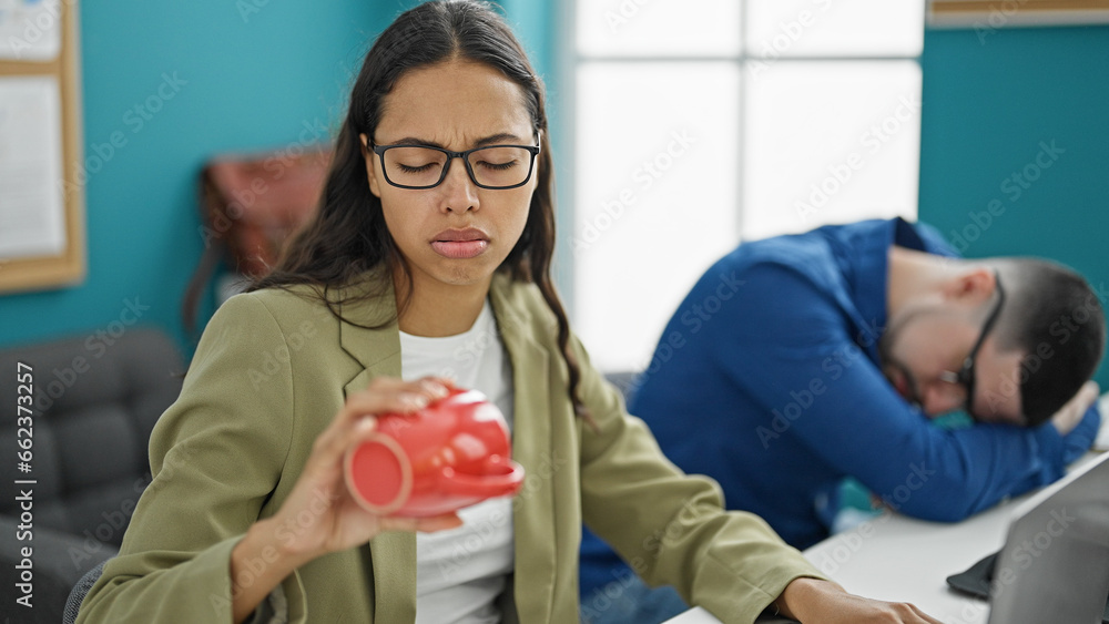 Canvas Prints Exhausted office workers, man and woman, clutching empty coffee cups after a tiring day working