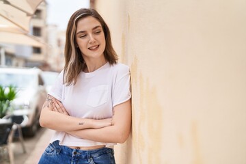 Young woman smiling confident standing with arms crossed gesture at street