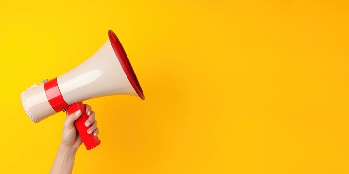 Hand holding a megaphone on a yellow background with empty space beside it for your text. generative AI