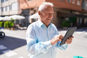 Middle age grey-haired man smiling confident using touchpad at street - obrazy, fototapety, plakaty