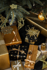Black and gold gift boxes with bows under the Christmas tree, Merry Christmas and Happy New Year