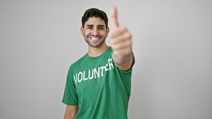 Young hispanic man volunteer doing thumb up smiling over isolated white background