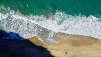 lone surfer with friend from sky vantage secluded beach Kauai
