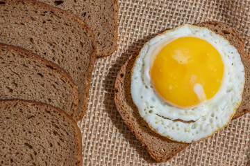 Sandwich with sunny side up egg on cotton background.