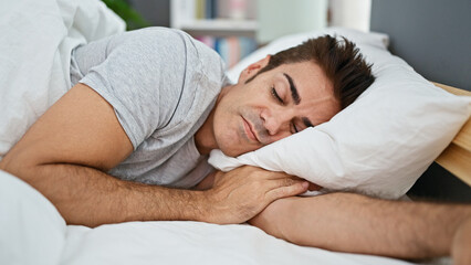 Young hispanic man lying on bed sleeping at bedroom