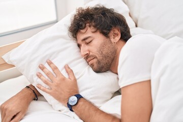 Obraz na płótnie Canvas Young hispanic man lying on bed sleeping at bedroom