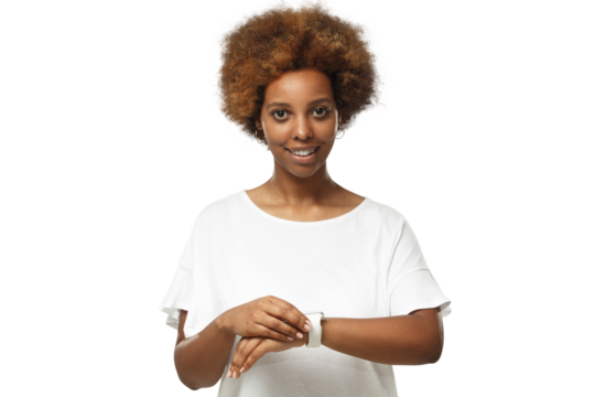 Young african american woman looking at camera, checking smartwatch, wearing wireless earphones and blank white t-shirt