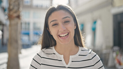 Young beautiful hispanic woman smiling confident standing at street