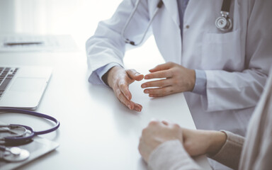 Doctor and patient discussing current health questions while sitting at the table in clinic office, only hands closeup. Medicine concept - 662384235
