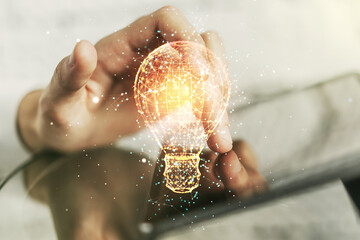 Creative light bulb illustration with finger presses on a digital tablet on background, future technology concept. Multiexposure - obrazy, fototapety, plakaty