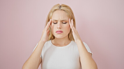Fototapeta premium Young blonde woman suffering for headache over isolated pink background