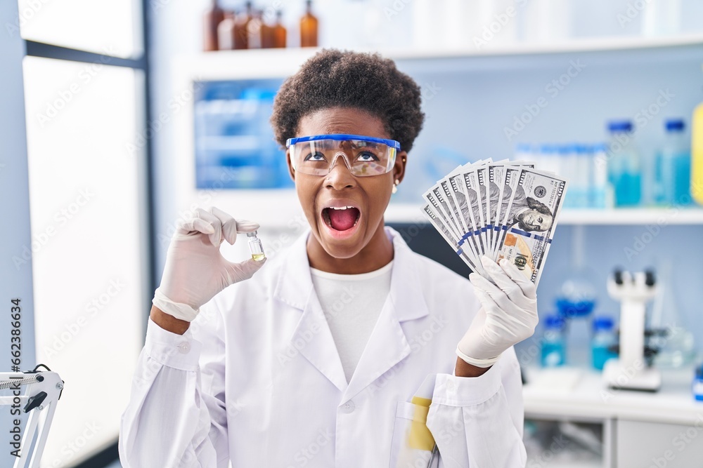 Poster african american woman working at scientist laboratory holding dollars angry and mad screaming frust