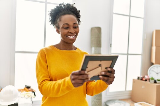 African american woman smiling confident looking photo at new home