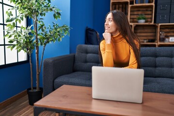 Obraz premium Young beautiful hispanic woman using laptop sitting on sofa at home