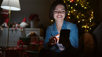 Young caucasian woman using smartphone sitting on the sofa at home