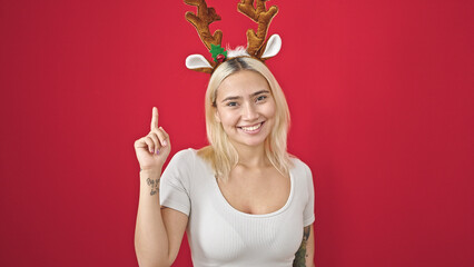 Young beautiful hispanic woman wearing reindeer christmas hat with idea expression over isolated...