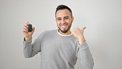 Hispanic man doing thumbs up holding key of new car over isolated white background