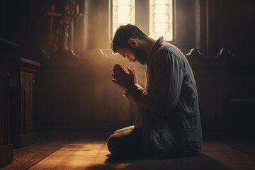A man is shown kneeling on the floor in prayer. This image can be used to depict faith, spirituality, devotion, or religious practices - obrazy, fototapety, plakaty