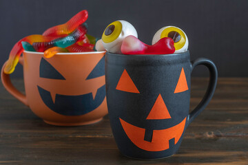 Jelly eyeballs in Halloween cup on dark background.