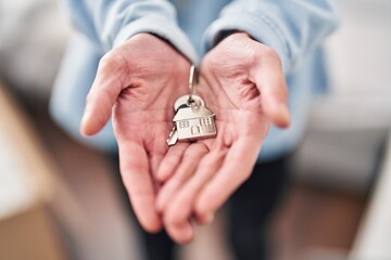 Young hispanic man holding key at new home