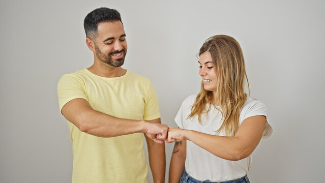 Man and woman couple smiling confident bumping fists over isolated white background