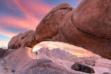 Young girl in Spitzkoppe area with picturesque stone arches and unique rock formations in...