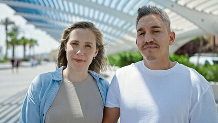 Obraz premium Man and woman couple standing together with serious face at park