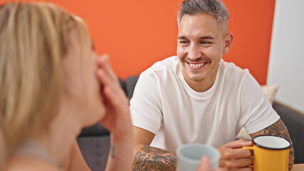 Man and woman couple holding cup of coffee speaking laughing a lot at dinning room