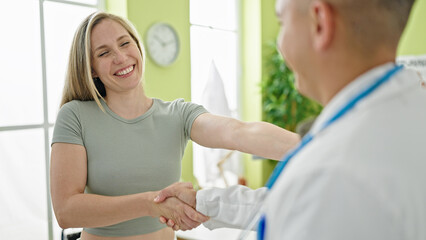 Man and woman doctor shaking hands with patient at the clinic