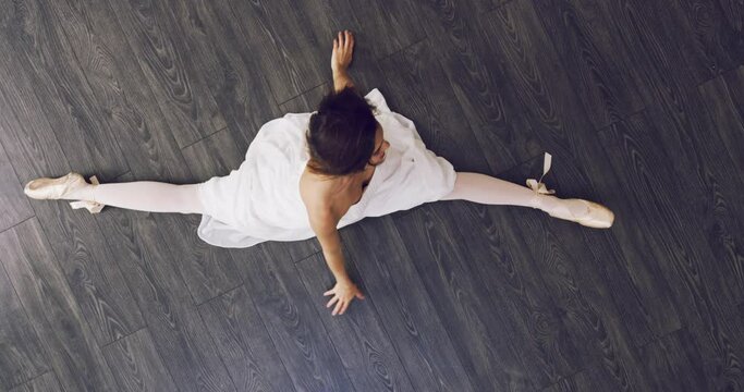Above, ballet and portrait of dancer on the floor in splits with legs, dancing and stretching in class or studio. Creative, movement and athlete training for performance or show on the ground