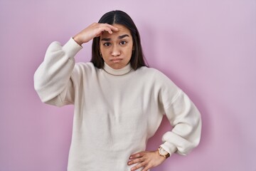 Young south asian woman standing over pink background worried and stressed about a problem with hand on forehead, nervous and anxious for crisis