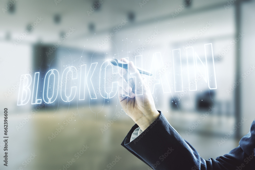 Poster man hand with pen draws abstract virtual blockchain technology hologram on blurred office background