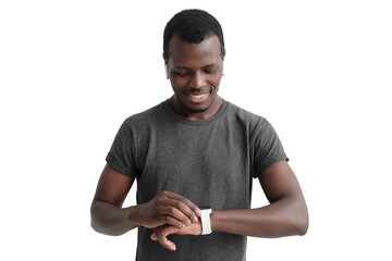 Young african american man checking smartwatch, wearing wireless earphones and gray t-shirt