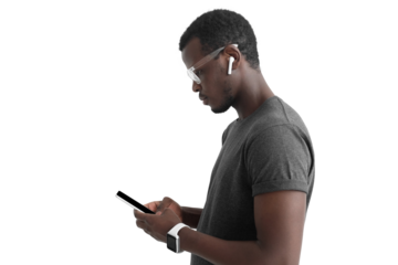 Side portrait of young african american man surfing using mobile phone, listening to music with white wireless earphones