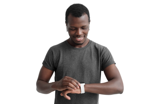Young african american man checking smartwatch, wearing wireless earphones and gray t-shirt
